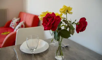 a table with a vase of roses and a wine glass at Casa Di Halepa in Chania Town