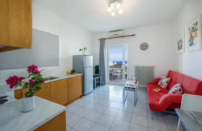 a kitchen and a living room with a red couch at Casa Di Halepa in Chania Town