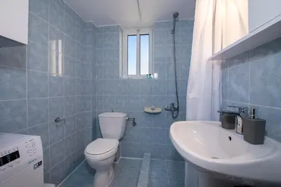 a blue tiled bathroom with a toilet and a sink at Casa Di Halepa in Chania Town