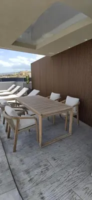 a group of wooden tables and chairs on a roof at Summertime Signature Suites in Agia Marina Nea Kydonias
