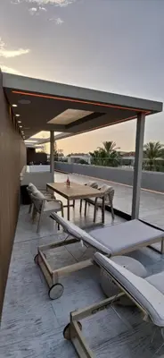 a patio with tables and chairs on a roof at Summertime Signature Suites in Agia Marina Nea Kydonias