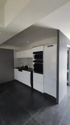 a kitchen with white cabinets and a white refrigerator at Summertime Signature Suites in Agia Marina Nea Kydonias