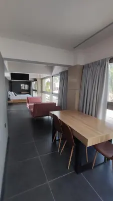 a living room with a wooden table and chairs at Summertime Signature Suites in Agia Marina Nea Kydonias