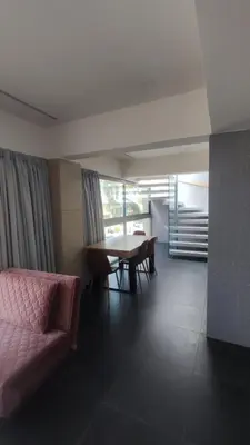 a living room with a table and a pink couch at Summertime Signature Suites in Agia Marina Nea Kydonias