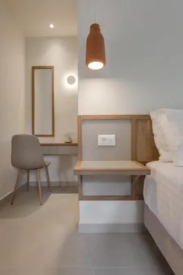 a bedroom with a bed and a desk and a chair at Villa Methexis in Arménoi