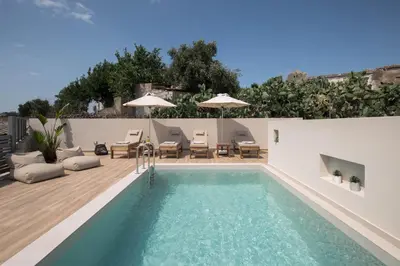 a swimming pool with chairs and a patio with at Villa Methexis in Arménoi