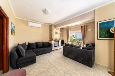 a living room with a couch and a tv at House On The Beach In Kera - BY APOKORONAS VILLAS in Kalyves