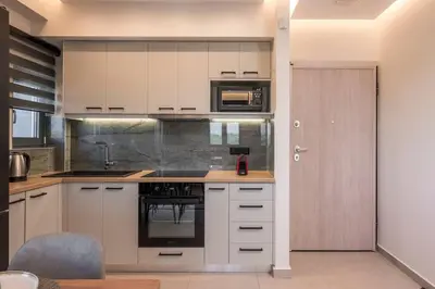 a kitchen with white cabinets and a stove at Aspect Luxury Apartments with Pool in Galangádhos