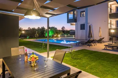 a dining table in the backyard of a house at Aspect Luxury Apartments with Pool in Galangádhos