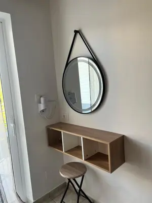 a mirror hanging on a wall next to a table at Dream Apartments in Palaiochóra