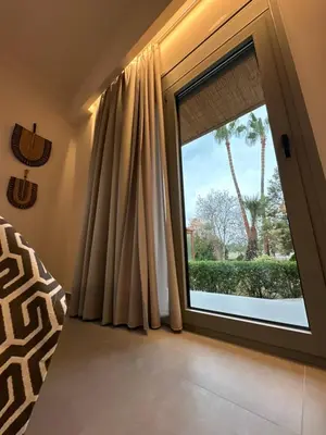 a bedroom with a window with a view of a palm tree at GREEN ESTATE villas in Arménoi