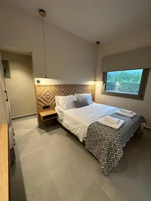 a bedroom with a large bed with a large window at GREEN ESTATE villas in Arménoi