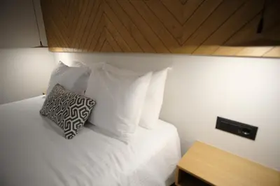 a bedroom with a bed with white sheets and a pillow at GREEN ESTATE villas in Arménoi
