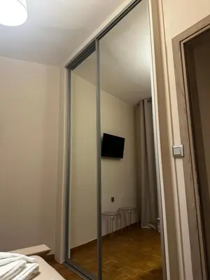 a sliding glass door in a bedroom with a television at Maria's Cozy Chania Apartment in Chania Town