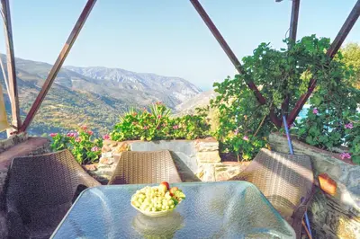 a bowl of fruit sitting on a table with chairs at Velanos Villas in Kefálion