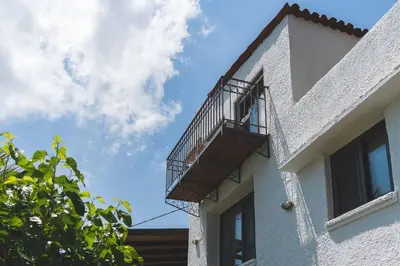 a balcony on the side of a white building at Labyrinth. The Wild life of Crete in Katsifarianá