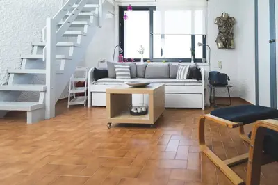 a living room with a couch and a staircase at Labyrinth. The Wild life of Crete in Katsifarianá