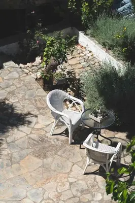 a dog sitting in a chair on a patio at Labyrinth. The Wild life of Crete in Katsifarianá