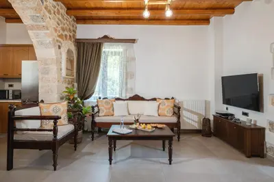 a living room with a couch and a tv at Villa Eliomylos in Souda