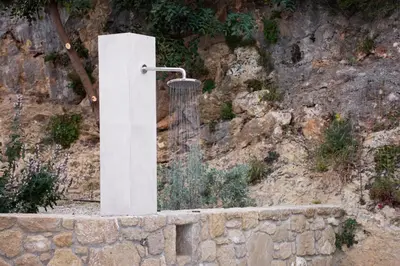 a stone wall with a shower in front of a mountain at Armour Eclectic Villa in Afráta