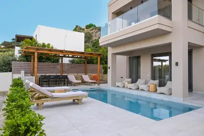 a villa with a swimming pool and a house at Armour Eclectic Villa in Afráta