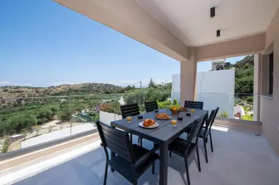 a dining room with a table and chairs and a large window at Armour Eclectic Villa in Afráta