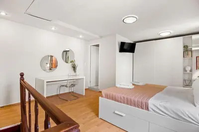 a bedroom with a bed and a desk and a television at Rodon maisonette in Chania Town