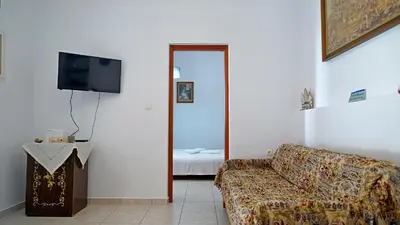 a living room with a couch and a television at Polyraki's Cottage in Chania Town