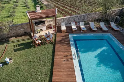 an overhead view of a swimming pool with chairs and a house at Villa Magia in Stérnai