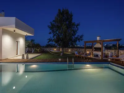 a swimming pool in front of a house at night at Villa Magia in Stérnai