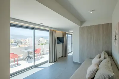 a living room with a couch and a large window at Sky-High Central Penthouse w. Stunning Views - 02 in Chania Town