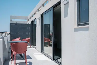 a balcony with chairs and a table on a building at Sky-High Central Penthouse w. Stunning Views - 02 in Chania Town