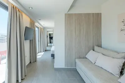 a living room with a couch and a wall with windows at Sky-High Central Penthouse w. Stunning Views - 02 in Chania Town