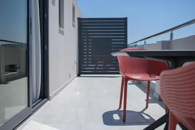 a balcony with a table and chairs on a building at Sky-High Central Penthouse w. Stunning Views - 02 in Chania Town