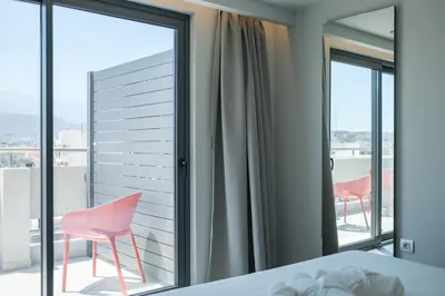 a bedroom with a bed and two chairs on a balcony at Sky-High Central Penthouse w. Stunning Views - 02 in Chania Town
