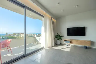 a living room with a tv and a large window at Sky-High 70sqm Penthouse w. Stunning Views - 05 in Chania Town