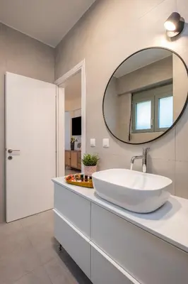a bathroom with a white sink and a mirror at Evora Suites in Chania Town