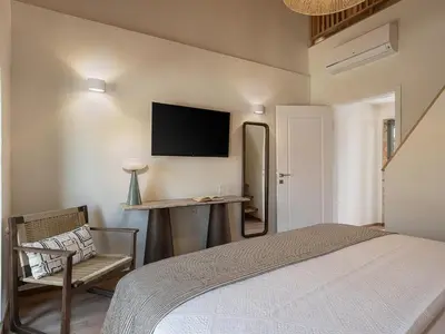 a bedroom with a bed and a desk and a television at Theros Home in Chania Town