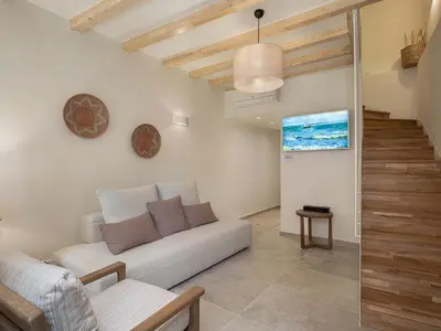 a living room with a couch and a staircase at Theros Home in Chania Town