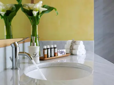 a bathroom sink with a vase of flowers and towels at Dorotheou House in Chania Town