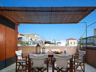 a patio with a table and chairs on a balcony at Dorotheou House in Chania Town