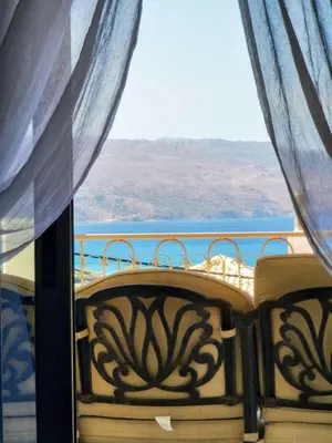 a balcony with a view of the ocean from a window at Douranakis house Seaview Apartment in Chania Town