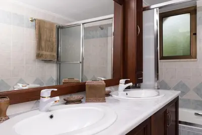 a bathroom with two sinks and a mirror at Douranakis house Seaview Apartment in Chania Town