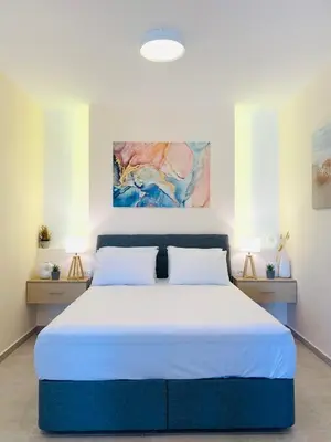a bedroom with a large bed with two lamps at Paleochora Beach Studio (BRAND NEW) in Palaiochóra