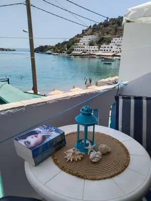 a cake on a table with a view of a beach at Notos Rooms in Loutro
