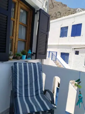 a blue and white chair sitting on a balcony at Notos Rooms in Loutro