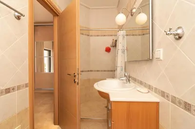 a bathroom with a sink and a mirror and a shower at Marika Seaside Villa in Yialós