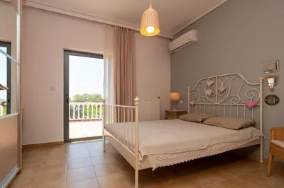 a bedroom with a bed and a large window at Marika Seaside Villa in Yialós