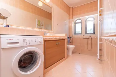 a bathroom with a washing machine and a toilet at Marika Seaside Villa in Yialós