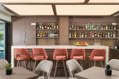 a bar in a restaurant with orange stools at Elia Agia Marina Resort in Agia Marina Nea Kydonias